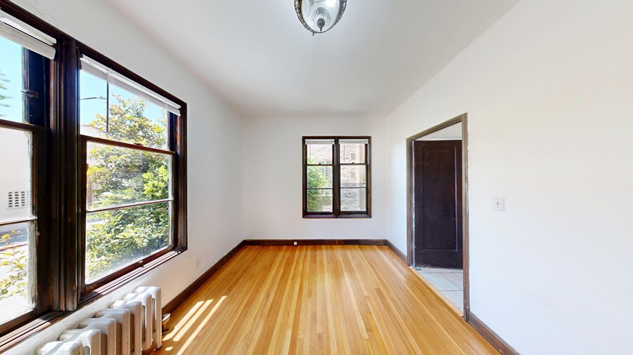 A room with wooden floors and a large window.